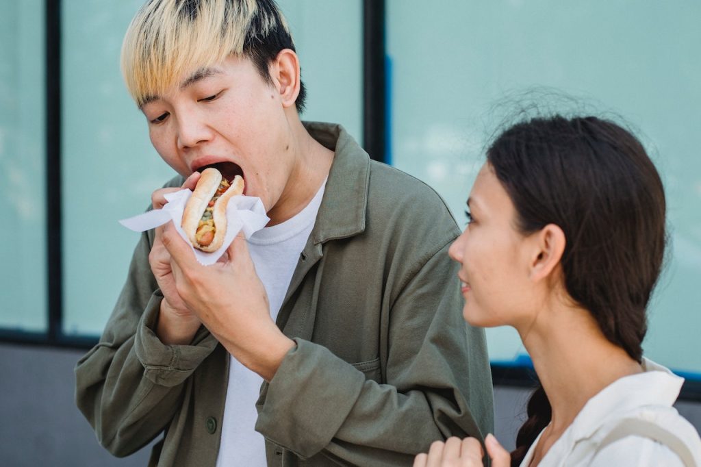person eating a hotdog sandwich
